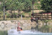 Salah satu pengunjung saat menjajal flying fox di Situ Cikamuning. (Istimewa)