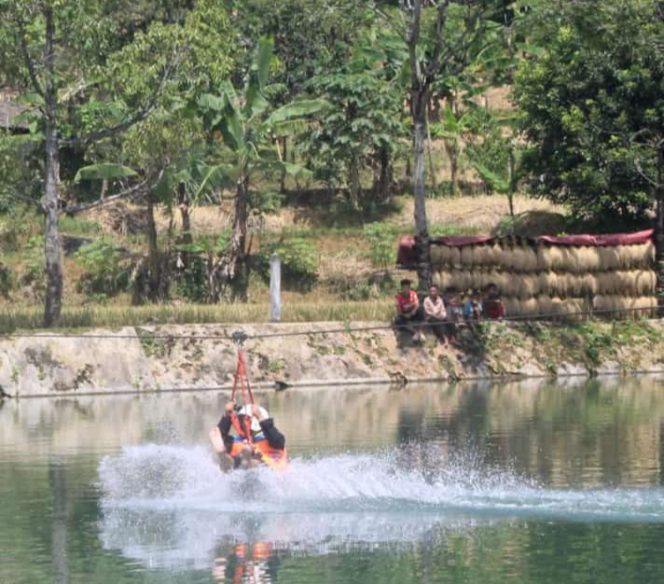 Salah satu pengunjung saat menjajal flying fox di Situ Cikamuning. (Istimewa)