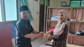 Kepala Desa Cikamunding, Yayan Hendayana (kiri) saat menerima bantuan untuk korban gempa Cianjur yang digalang oleh masyarakat Cikamunding. (istimewa)