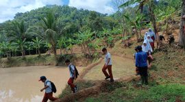 Para pelajar SDN 1 dan 3 Cikamunding saat akan pergi sekolah. Mereka terpaksa melewati persawahan dan hutan agar lebih cepat datang ke sekolah. (Istimewa)