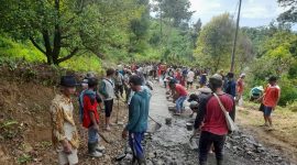 Warga Cikamuning saat bahu membahu memperbaiki jalan rusak di Desa Pasirbungur. (Istimewa)