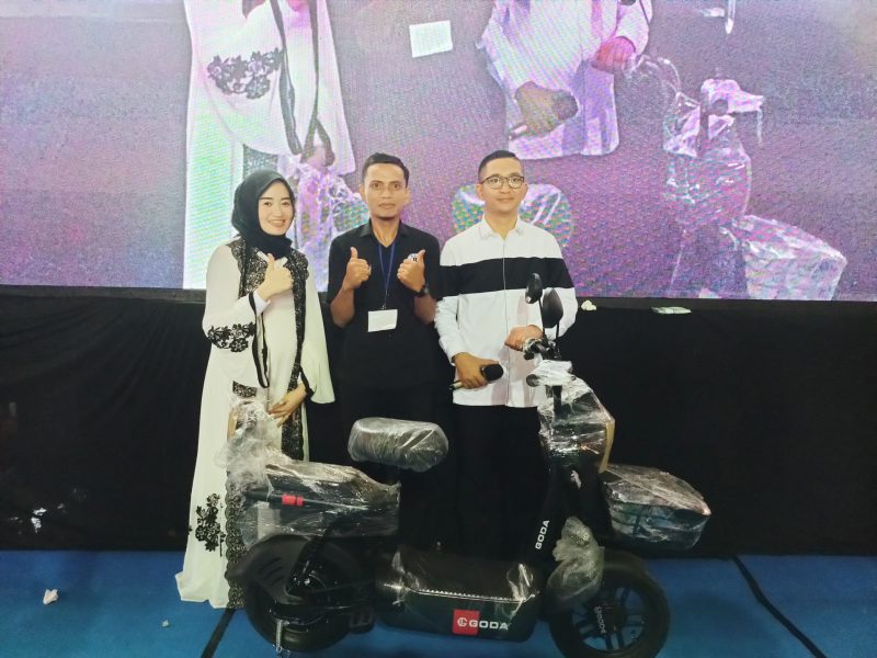 Ketua BPC Gapensi Lebak, Nabil Jayabaya (kanan) didampingi istri Intan Nabil Jayabaya (kiri) saat menyerahkan doorprize sepeda listrik kepada salah satu warga. (Istimewa)