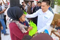 Ketua DPC Peradi Rangkasbitung, Jimi Siregar saat memberikan bingkisan secara simbolis kepada anak stunting di Kabupaten Lebak. (Istimewa)