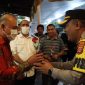 Kapolres Cilegon, AKBP Eko Tjahyo Untoro saat membagikan bunga kepada umat Nasrani yang melakukan ibadah. (Istimewa)