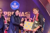 Uas Romansah saat menerima penghargaan guru Dedikatif tingkat nasional. (Istimewa)