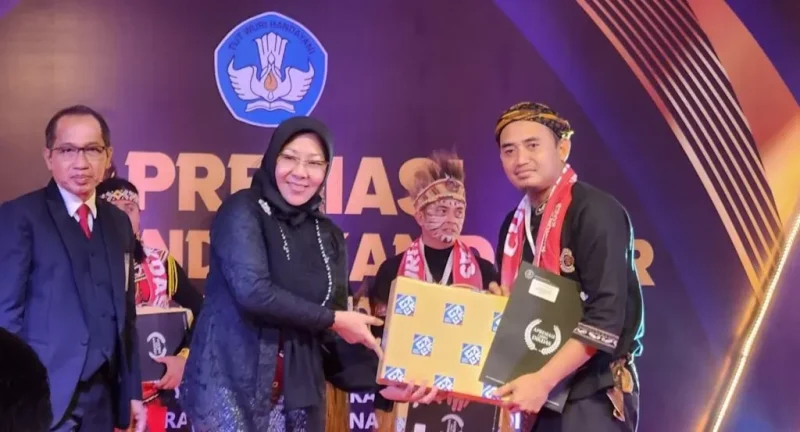 Uas Romansah saat menerima penghargaan guru Dedikatif tingkat nasional. (Istimewa)