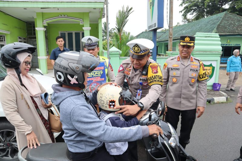 Kasatlantas Polres Lebak, AKP Mulya Sugiharto bersama Kapolres Lebak AKBP Suyono saat memberikan bantuan helm kepada salah satu pelanggar lalulintas. (Istimewa)