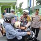 Kasatlantas Polres Lebak, AKP Mulya Sugiharto bersama Kapolres Lebak AKBP Suyono saat memberikan bantuan helm kepada salah satu pelanggar lalulintas. (Istimewa)