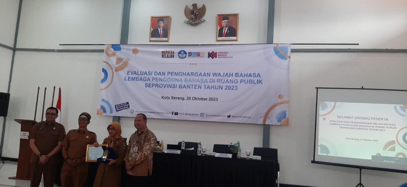 Kepala SMAN 1 Rangkasbitung, Ucu Lena Murtadewi (tengah) saat menerima trophy dari kantor Bahasa Banten. (istimewa)