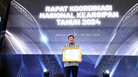 Kepala Dinas Perpustakaan dan Kearsipan (DPK) Kota Cilegon, Ismatullah saat menerima penghargaan ANRI untuk Pemkot Cilegon. (Istimewa)