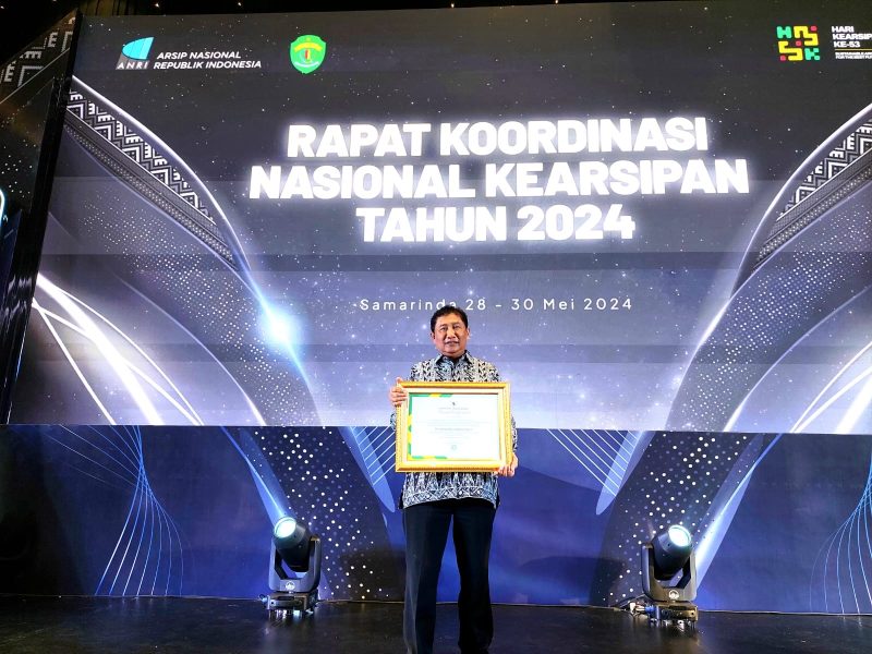 Kepala Dinas Perpustakaan dan Kearsipan (DPK) Kota Cilegon, Ismatullah saat menerima penghargaan ANRI untuk Pemkot Cilegon. (Istimewa)