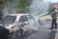 Kondisi mobil Hyundai Avega yang terbakar saat dilakukan pemadaman oleh Tim Damkar Kabupaten Lebak. (Istimewa)