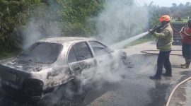 Kondisi mobil Hyundai Avega yang terbakar saat dilakukan pemadaman oleh Tim Damkar Kabupaten Lebak. (Istimewa)