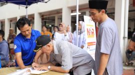 Foto seorang bapa saat menulis di Pasar Anyar, Pemerintah Kota (Pemkot) Tangerang menyuguhkan sebuah program yang menjanjikan, yaitu layanan 'NIB Merdeka'. (Istimewa/Dailyhits)