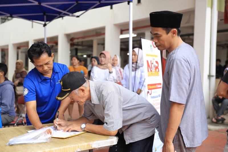 Foto seorang bapa saat menulis di Pasar Anyar, Pemerintah Kota (Pemkot) Tangerang menyuguhkan sebuah program yang menjanjikan, yaitu layanan 'NIB Merdeka'. (Istimewa/Dailyhits)