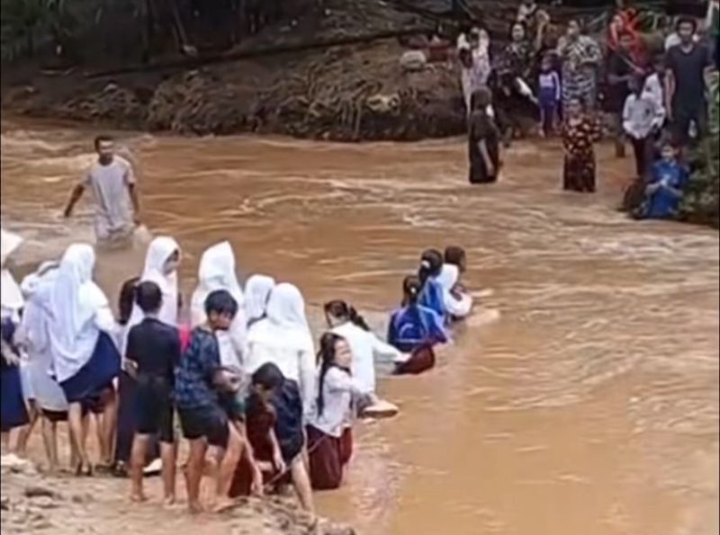 Para pelajar saat menyeberangi sungai dengan arus deras untuk berangkat dan pulang sekolah. (FOTO Tangkap Layar video)