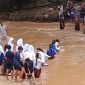 Para pelajar saat menyeberangi sungai dengan arus deras untuk berangkat dan pulang sekolah. (FOTO Tangkap Layar video)