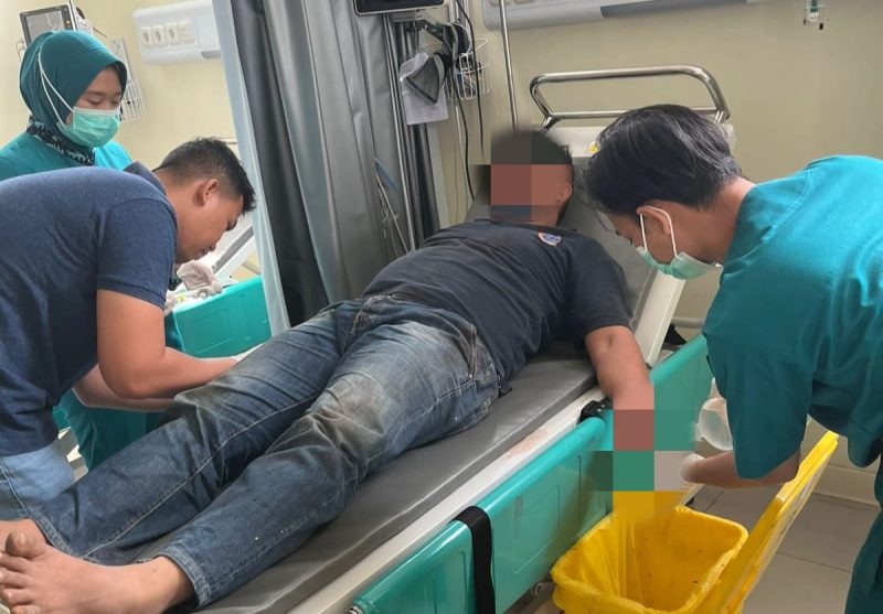 Salah satu petugas saat mendapatkan penanganan medis usai diamuk massa. (Istimewa)